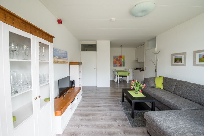 Geraeumiger Innenbereich von 't Kerckeland - Apartment Kerckeland 88, De Koog, Texel mit gemuetlicher Sitz- und Essecke.