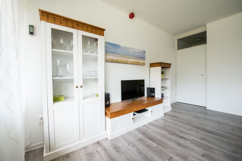 Stilvolles Wohnzimmer in 't Kerckeland - Apartment Kerckeland 88, De Koog, Texel mit Unterhaltungsmoeglichkeiten und Glasschrank.
