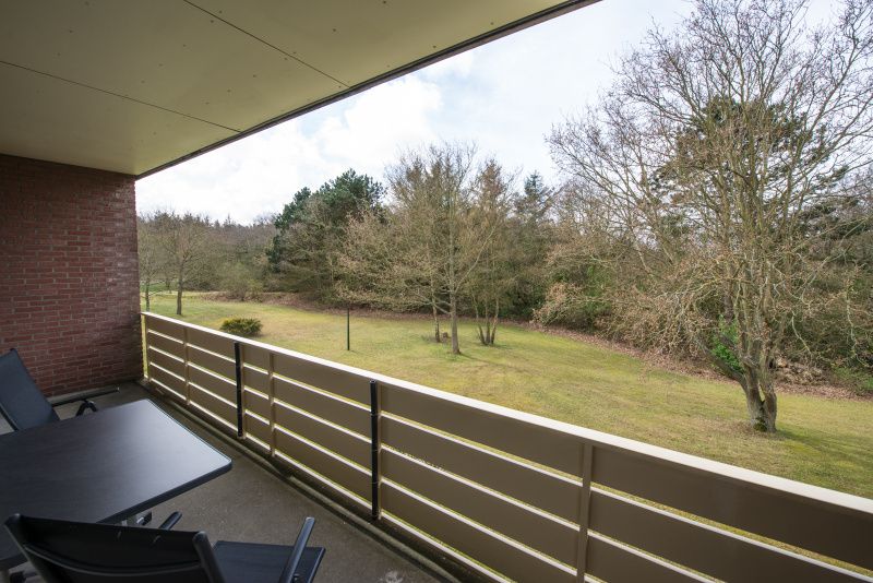 Der Balkon von 't Kerckeland - Appartement Kerckeland 88, De Koog, Texel bietet Aussicht auf die gruene Umgebung und Raum fuer Entspannung.