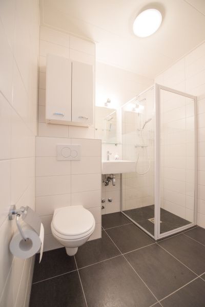 Modernes Badezimmer in 't Kerckeland - Apartment Kerckeland 88, De Koog, Texel mit Dusche, Waschbecken und Toilette in schlichter Ausfuehrung.
