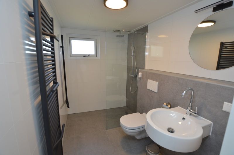 Modernes Badezimmer des Ferienhauses Stappeland 203 in De Koog Texel, mit begehbarer Dusche und stilvollem Waschbecken.
