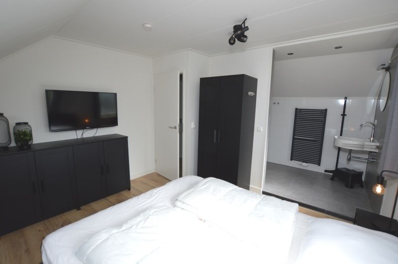Ferienhaus Stappeland 203 in De Koog Texel, Schlafzimmer mit eigenem Bad und moderner Einrichtung.