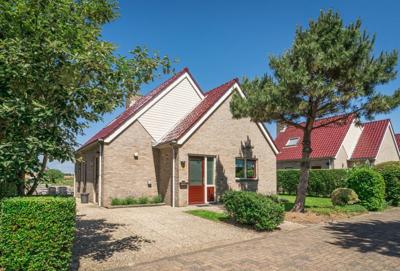 Enjoy the tranquility at Villa 6 persons in De Koog, Texel, a cozy vacation home with an inviting entrance and surrounded by nature.