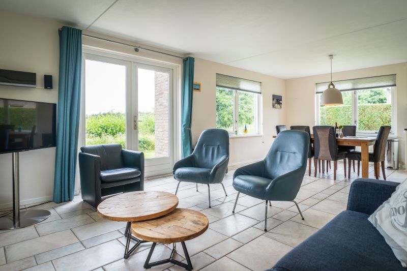 Spacious living room in Villa 6 persons, De Koog, Texel. Comfortable sitting area overlooking the garden of this vacation home on the Wadden Islands.