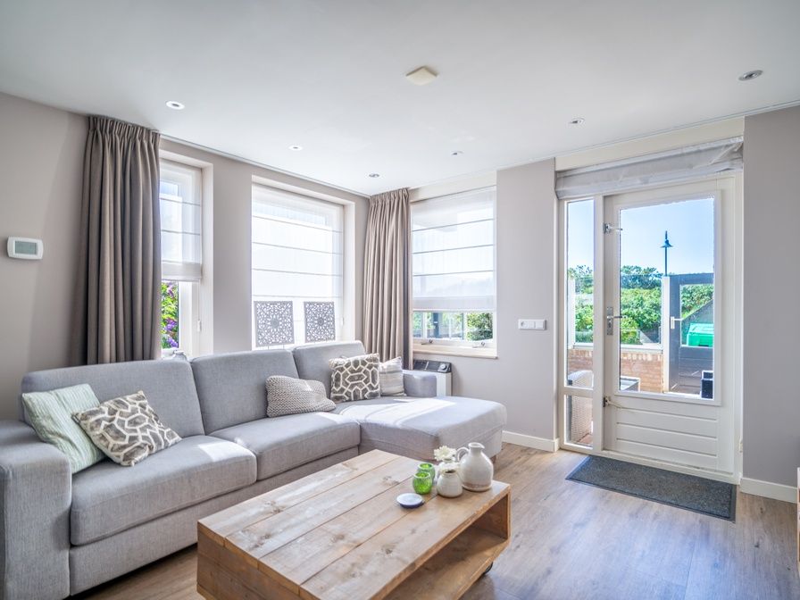 Cozy living room in Apartment Juliana 034 Eilandzicht, De Koog, Texel with comfortable sofa and garden view.