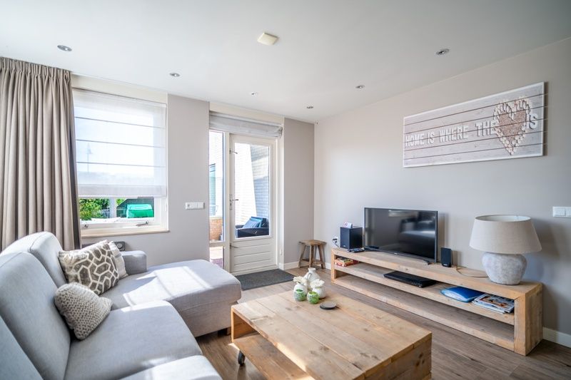 Stylish living room in Apartment Juliana 034 Eilandzicht, De Koog, Texel with flat-screen TV and access to outdoor space.