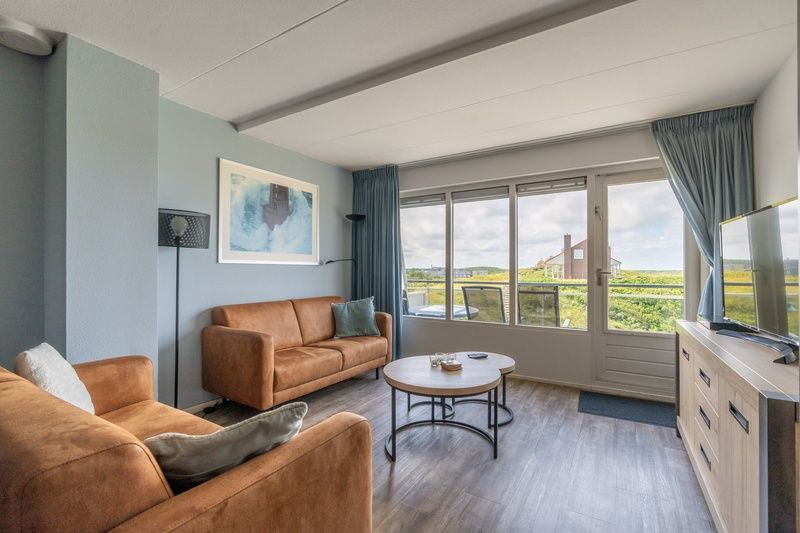 Helles Wohnzimmer der Ferienwohnung Juliana 096 Insel- und Meerblick, De Koog, Texel mit moderner Einrichtung und Meerblick.