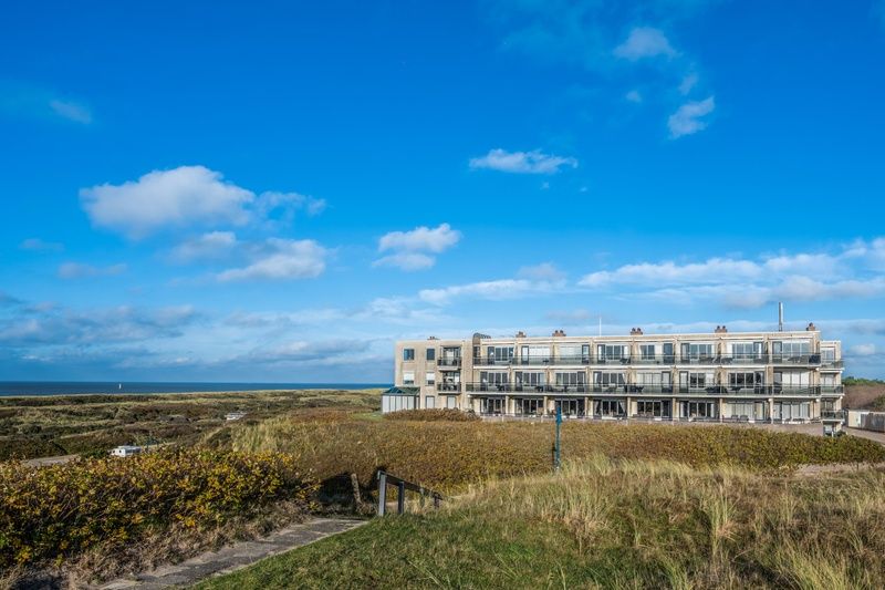 Aussenansicht des Appartements Juliana 096 Insel- und Meerblick, De Koog, Texel mit Blick auf das Meer und die Duenen.