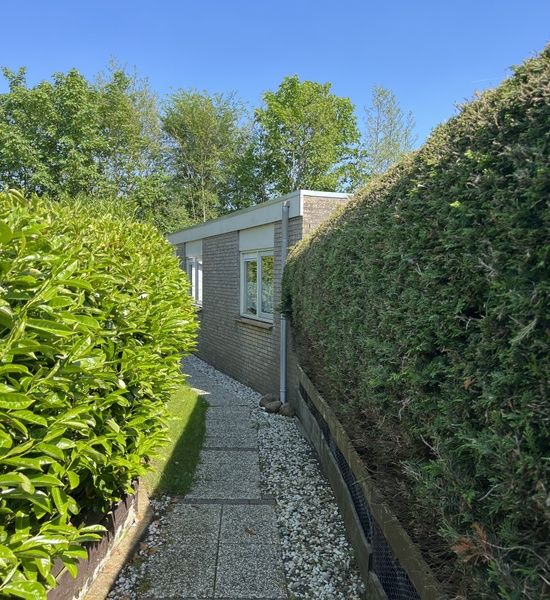 Dining area in Bungalow 't Luwe Land 5B in De Koog Texel with wooden table and chairs.