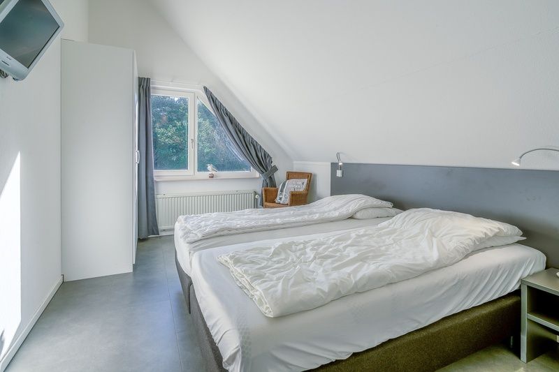 Spacious bedroom in Holiday home Honeysuckle 93 with sauna, De Koog, Texel, with modern amenities.