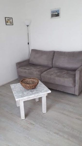 Comfortable sitting area in Apartment Dorpsstraat 245 in De Koog, Texel with gray sofa.