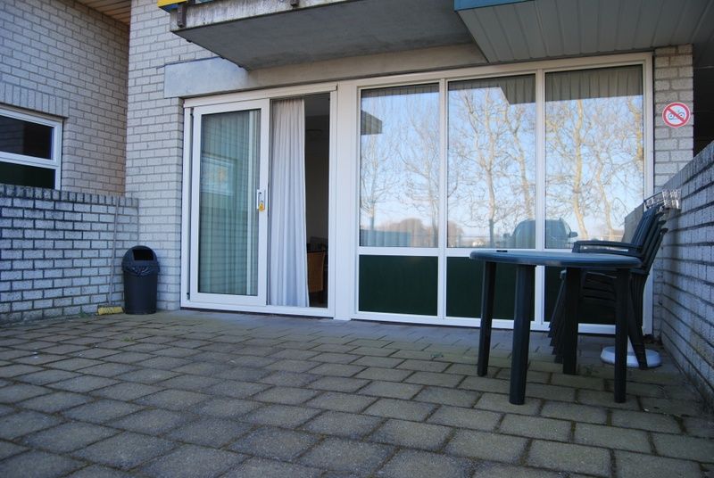 Sunny terrace at Apartment Dorpsstraat 245 in De Koog, Texel with garden furniture.