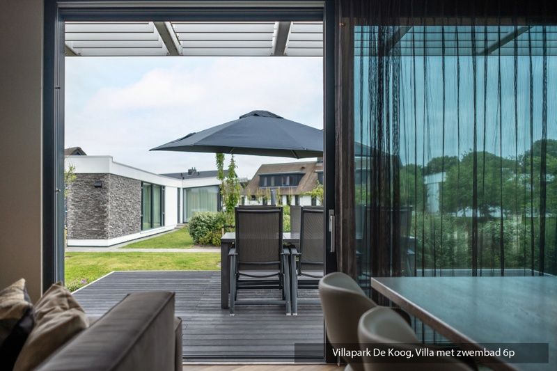Luxury family villa with pool in De Koog, Texel. Modern kitchen overlooking the Wadden Islands garden.