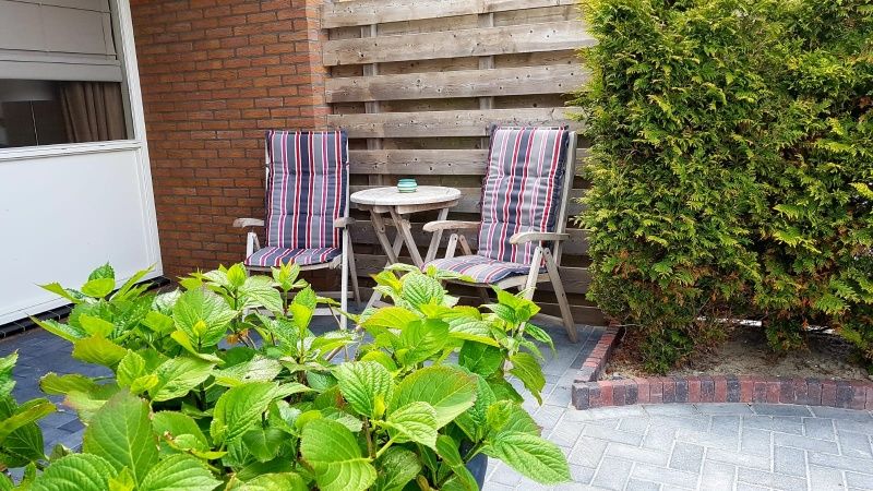 Private Terrasse des Ferienhauses 2, De Koog, Texel mit bequemen Sitzgelegenheiten.