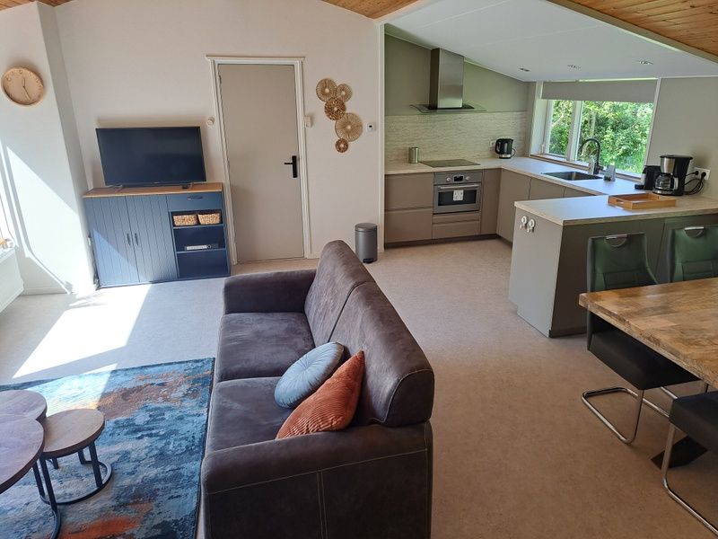 Modern living room in vacation home Hoog Koog 10, Bungalowpark Hoog Koog, De Koog, Texel with open kitchen.