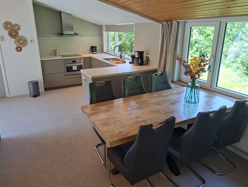 Open kitchen and dining area in vacation home Hoog Koog 10, Bungalowpark Hoog Koog, De Koog, Texel overlooking nature.