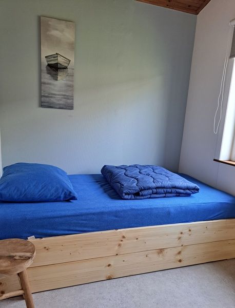Cozy single room in vacation home Hoog Koog 10, Bungalowpark Hoog Koog, De Koog, Texel with wooden bed.
