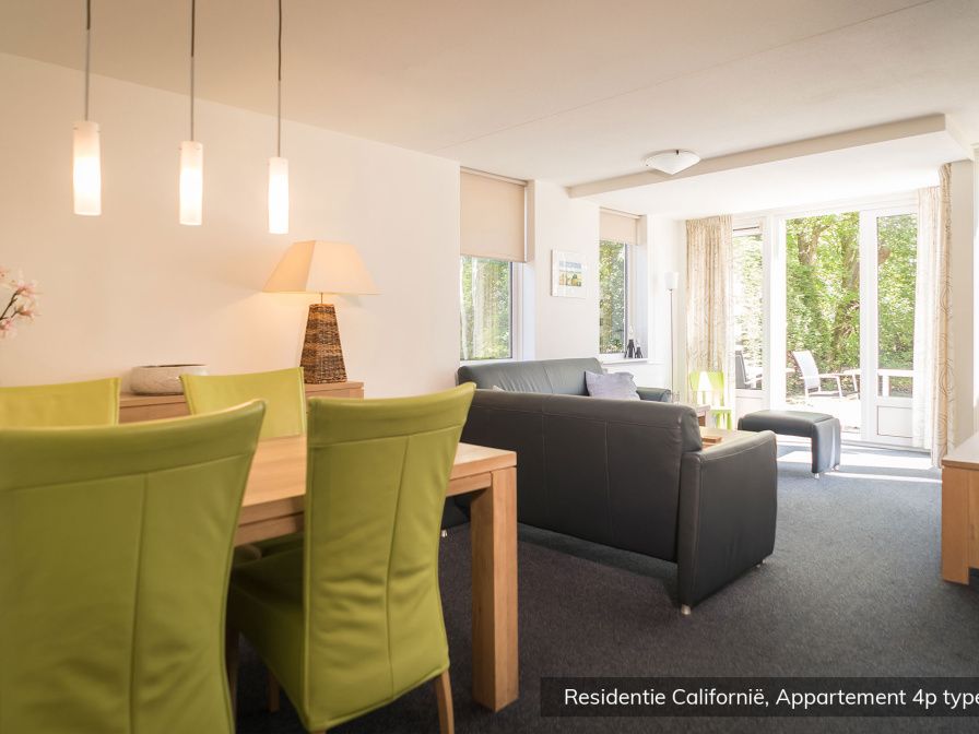 Spacious living room in Type 4 vacation home, De Koog, Texel. Comfortable sitting area with lots of natural light.