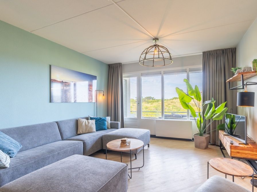 Gemuetliches Wohnzimmer der Ferienwohnung Juliana 044 Insel- und Meerblick in De Koog, Texel mit Blick auf die Duenen.