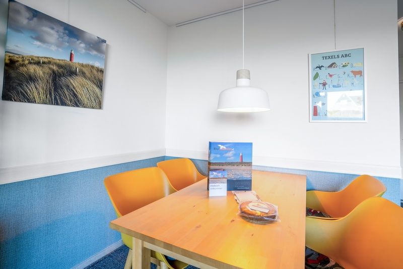 Dining area with colorful chairs in Apartment Juliana 068 Island and Sea View, De Koog, Texel.