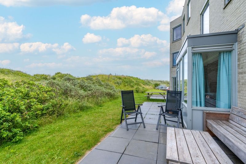 Outdoor area of Apartment Juliana 068 Island and Sea View, De Koog, Texel with seating and greenery.