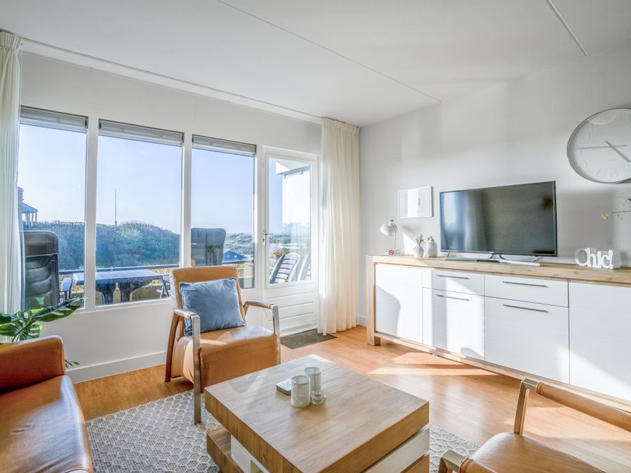 Gemuetliches Wohnzimmer im Appartement Juliana 052 Insel- und Meerblick, De Koog, Texel mit schoener Aussicht auf die Duenen.