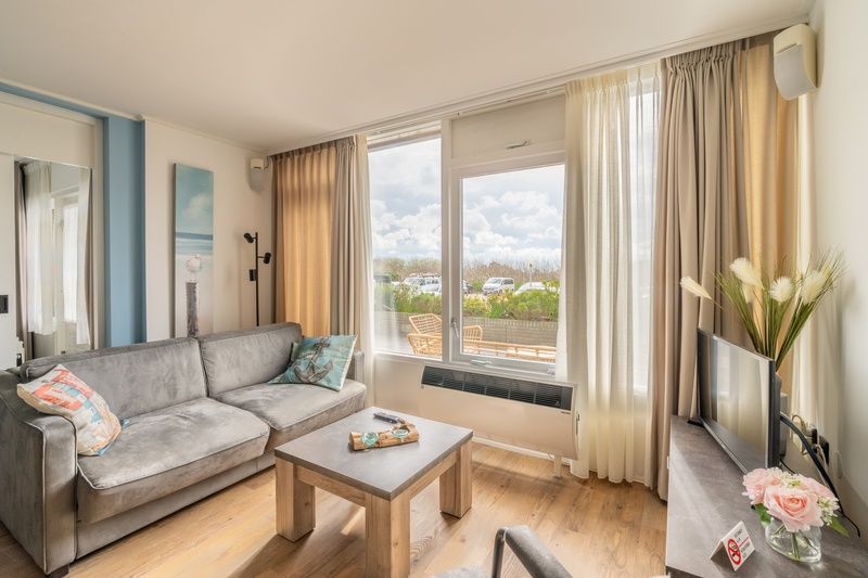 Sitzecke im Appartement Juliana 076 Eilandzicht, De Koog, Texel, mit Blick auf die Natur und einer einladenden Atmosphaere.