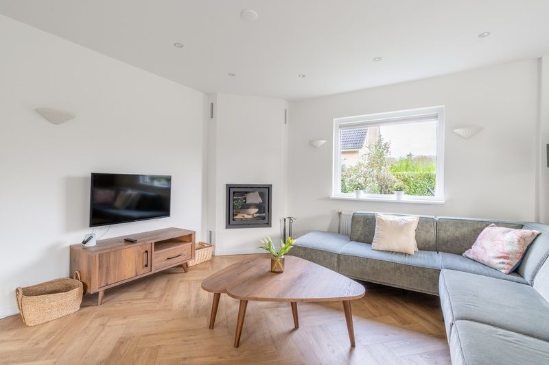 Cozy living room of Stappeland 197 in De Koog, Texel with modern furnishings and fireplace.
