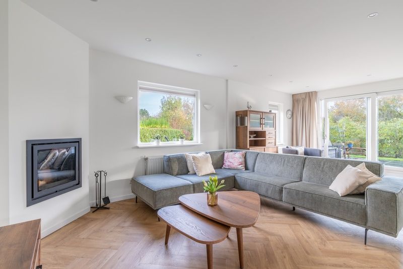 Spacious living room in Stappeland 197, vacation home De Koog, Texel with corner sofa and garden view.