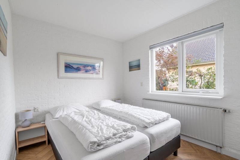 Bedroom storage in Stappeland 197, vacation home De Koog, Texel with closet and mirror.