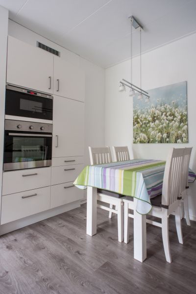 't Kerckeland - Apartment Kerckeland 92 in De Koog: Dining area in the kitchen with colorful tablecloth and artwork.