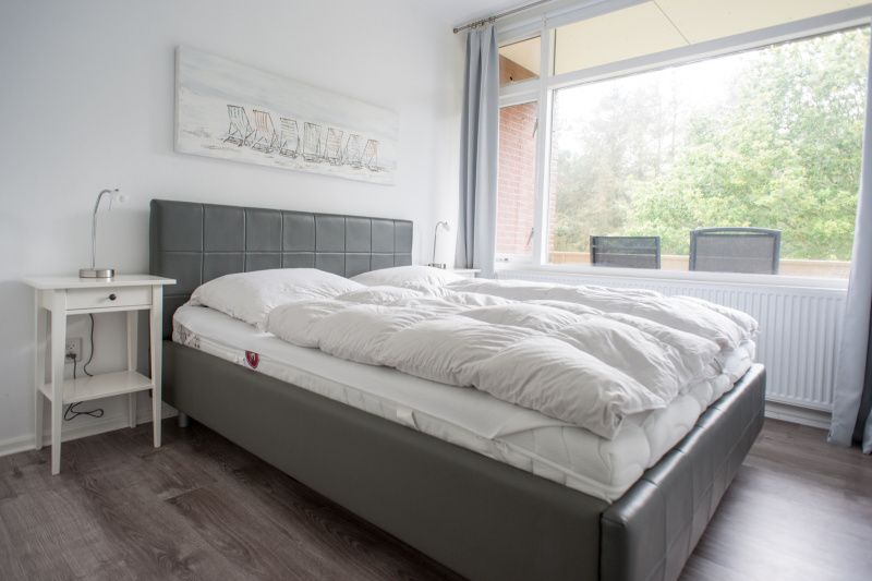 't Kerckeland - Apartment Kerckeland 92, De Koog, Texel: Bedroom with comfortable double bed and view of nature.