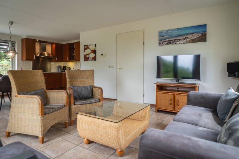 Cozy sitting area in Villa 304, De Koog, Texel with modern furnishings and television for relaxation.