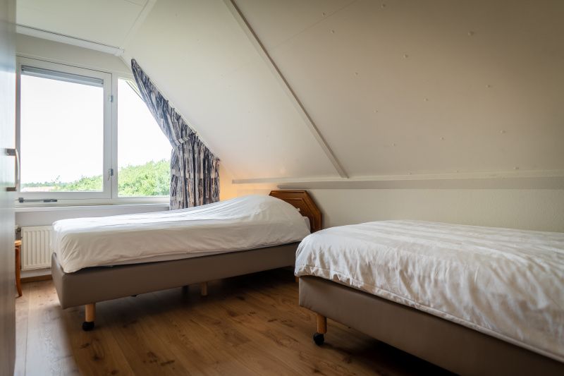 Cozy bedroom with two single beds in Villa 304, De Koog, Texel on the Wadden Islands.