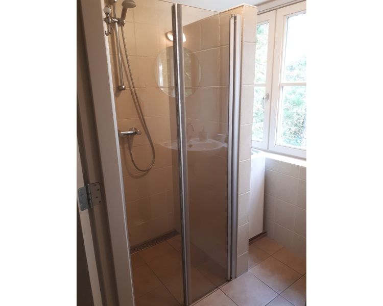 Spacious shower in Pauwenhof Texel, De Koog with modern glass doors and natural light.