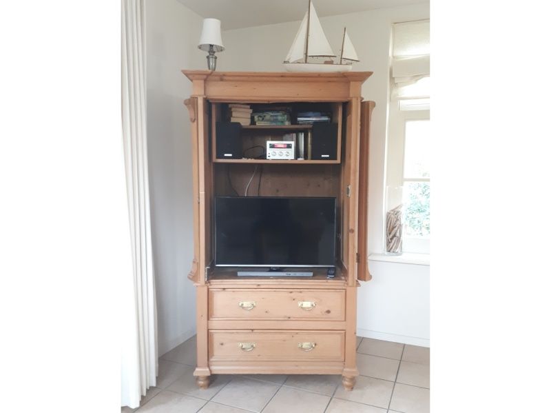 Wooden cabinet in Pauwenhof Texel, De Koog with TV and audio equipment for relaxation.