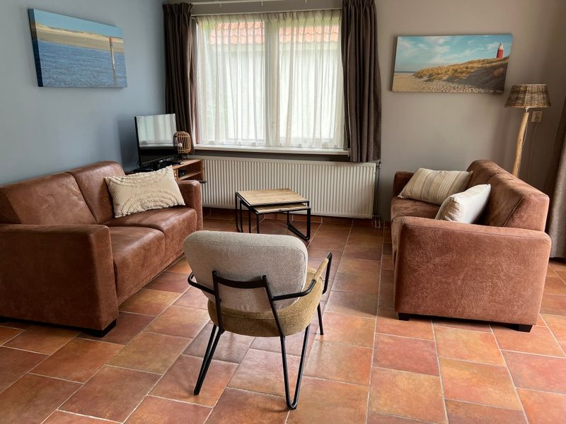Cozy living room in Landgoed Springtij - Koetshuis 3, vacation home De Koog, Texel with comfortable seating.