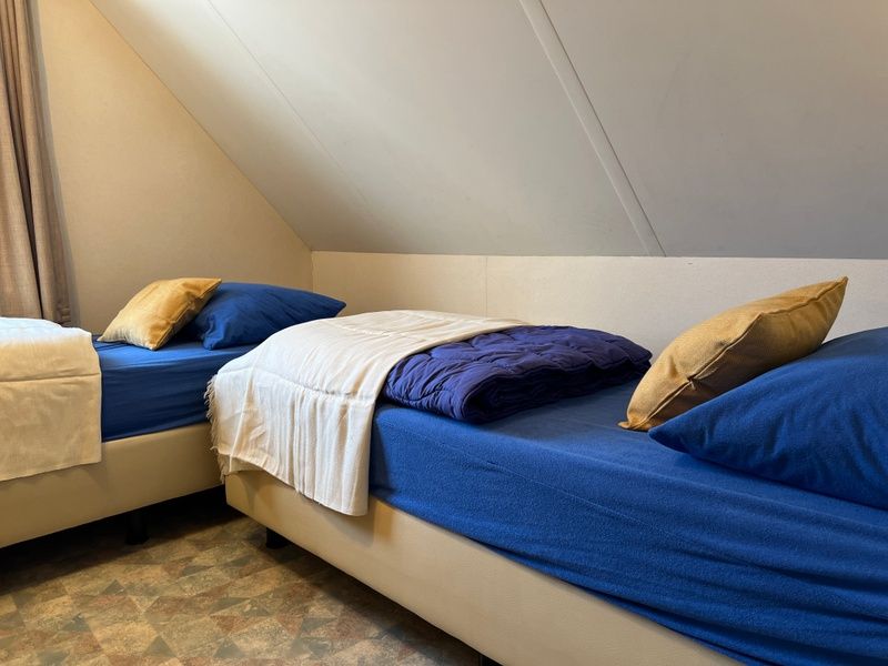 Cozy bedroom in Landgoed Springtij - Koetshuis 3, vacation home De Koog, Texel with two single beds.