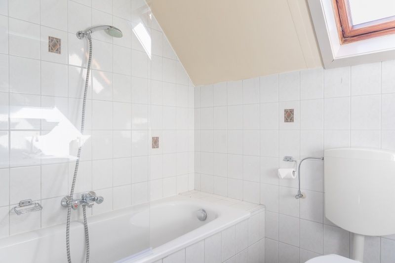 Bathroom with bath in Landgoed Springtij - Koetshuis 3, vacation home De Koog, Texel with light tile finish.