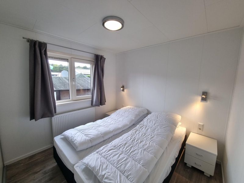 Comfortable bedroom in Chaletpark Bregkoog - Chalet 240 De Texelse Berg, De Koog, Texel with double bed and view.