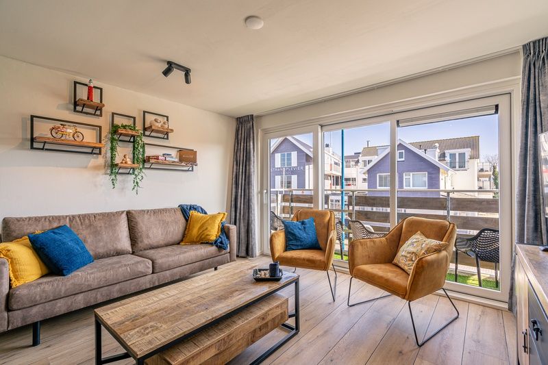 Helles Wohnzimmer im Appartement Anna 220, De Koog, Texel mit moderner Einrichtung und Balkonblick.