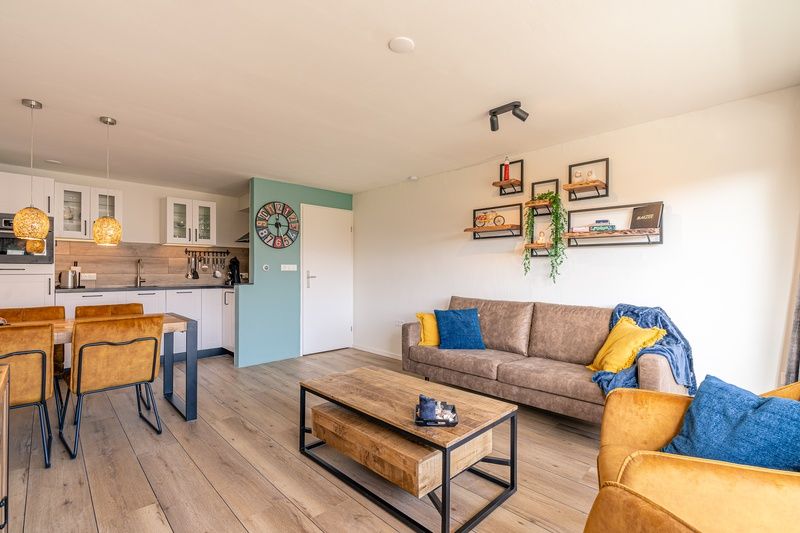 Offene Kueche und Wohnzimmer im Appartement Anna 220, De Koog, Texel mit Essecke und gemuetlicher Atmosphaere.