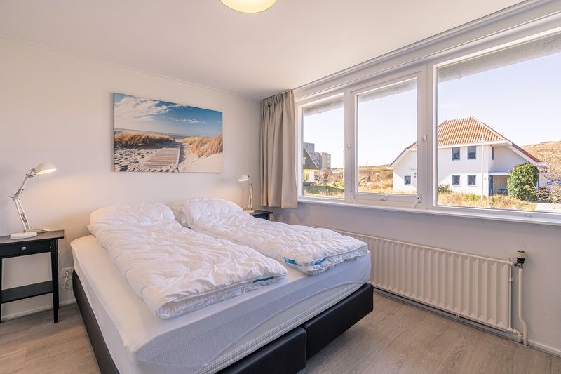 Schlafzimmer mit Doppelbett in De Zandduyn, De Koog, Texel, mit Blick auf die Duenen.