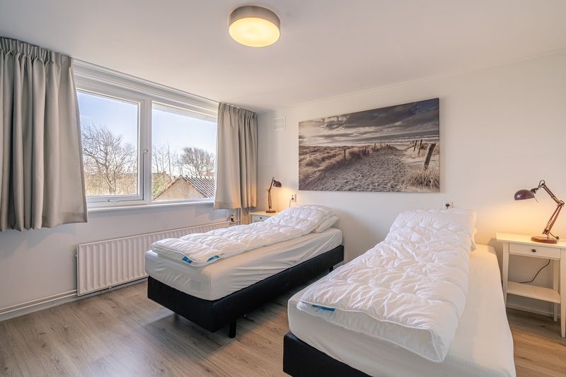 Zweibettzimmer im Ferienhaus De Zandduyn, De Koog, Texel, mit ruhiger Einrichtung und grossen Fenstern.