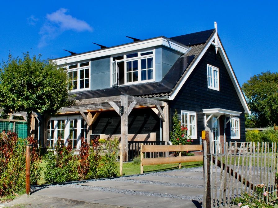 Residence Rustiek vakantiehuis in De Koog, Texel met houten gevel en groene tuin.