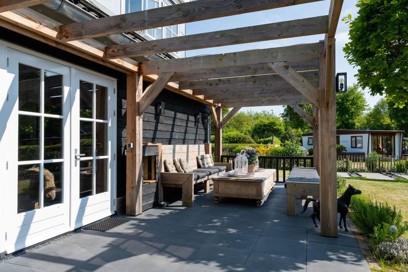 Veranda van vakantiehuis Residence Rustiek in De Koog, Texel met houten meubels.