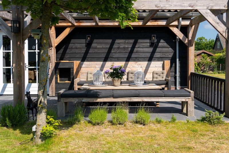 Gezellig terras bij Residence Rustiek in De Koog, Texel met zitbank en tafels.