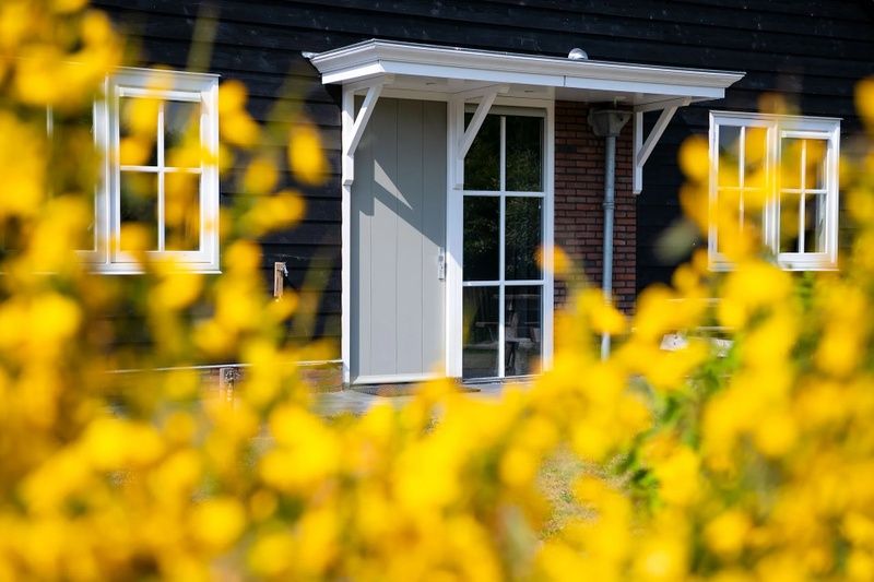 Ingang van Residence Rustiek in De Koog, Texel met kleurrijke bloemen.