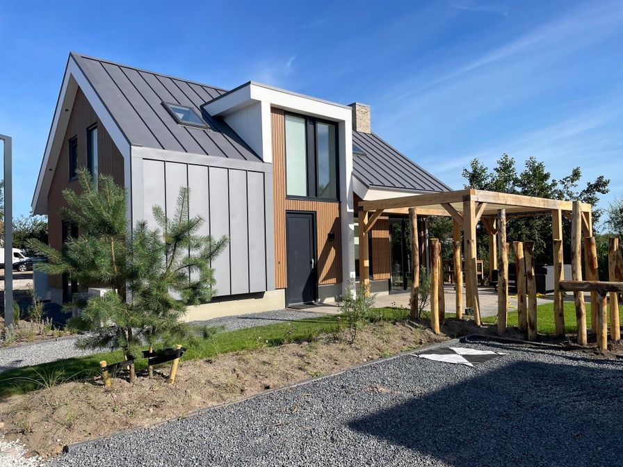 Duinvilla Wellness 6 in De Koog, Texel, modern vacation home with wooden facade and veranda.