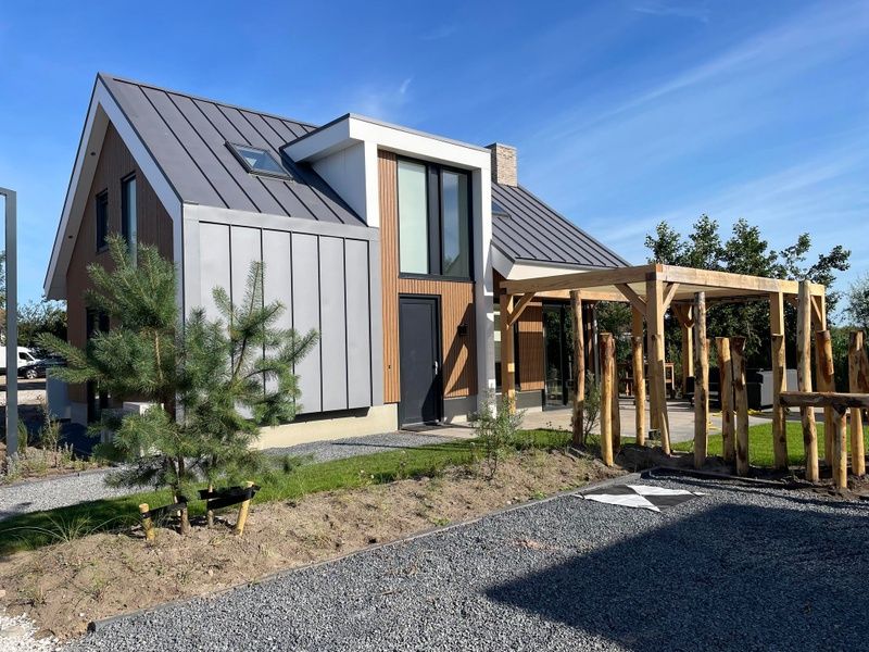 Exterior of Duinvilla Wellness 6, Texel, with wooden elements and green surroundings.